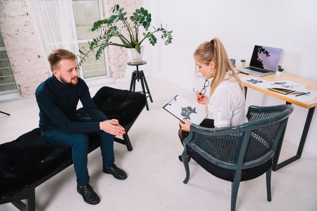 mision Female psychologists in a therapy session with male patient – representing Kaerus Recruitment’s focus on mental health and therapy roles.